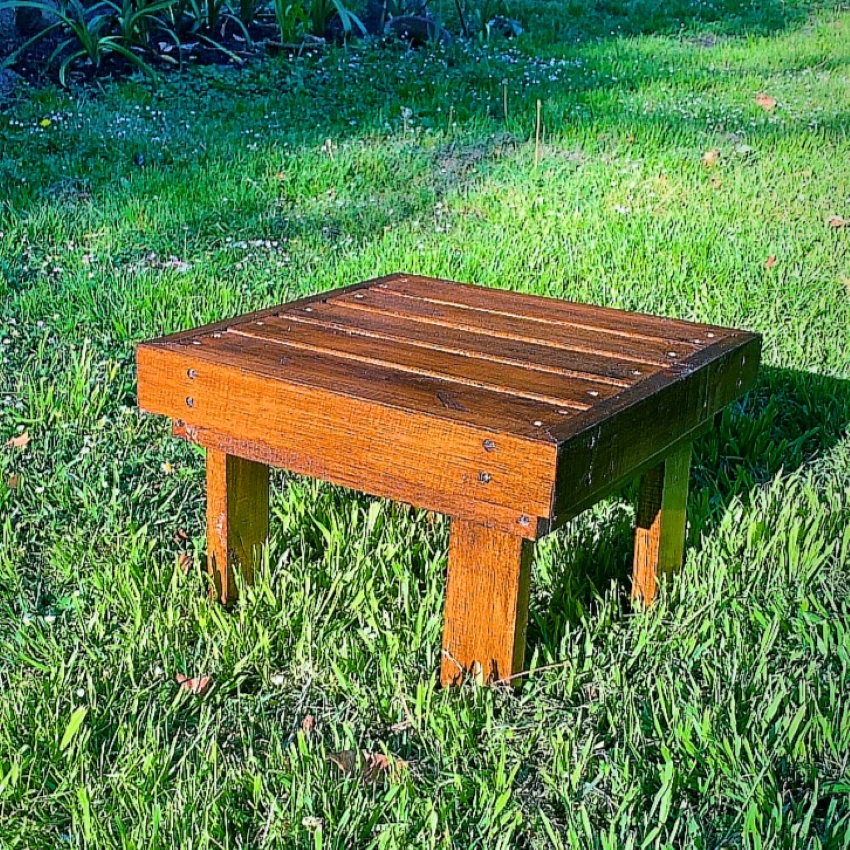 Mesa ratona de madera lustrada sobre el césped